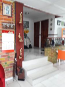 sala de estar con escaleras y pared de ladrillo en B&B Grand Royal Inn, en Barranquilla