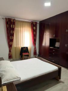 um quarto com uma cama, uma televisão e cortinas em Shamet em Delvinë