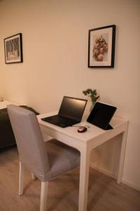 einen Schreibtisch mit zwei Laptops und einem Stuhl in der Unterkunft Kodikas hyvin varusteltu yksiö, autopaikalla in Vantaa