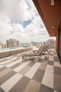 - un balcon avec deux bancs au-dessus d'un bâtiment dans l'établissement Metro Brooklin - Be Urban, à São Paulo