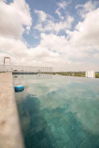 a large pool of water with a pier and buildings at Metro Brooklin - Be Urban in Sao Paulo