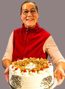 an older woman is holding a large cake at Single Fewo scheiter beck in Feldberg