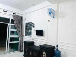 a room with two stools and a window with a fan at Minamo Homestay Modern Tengah Kota Payakumbuh in Payakumbuh