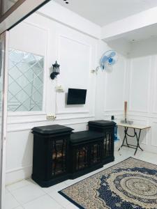 a living room with black stools and a tv at Minamo Homestay Modern Tengah Kota Payakumbuh in Payakumbuh