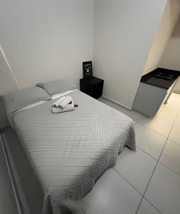 a bedroom with a bed with a phone on it at Apartamentos centrais junto ao calçadão in Ponta Grossa