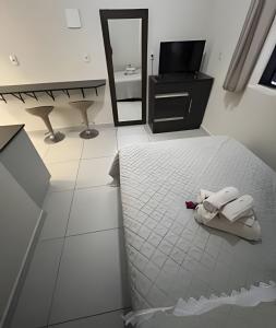 a bedroom with a bed and a sink and a mirror at Apartamentos centrais junto ao calçadão in Ponta Grossa