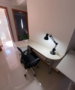 um escritório com uma secretária com um candeeiro e uma cadeira em Apartamento 2 quartos c/ garagem em Ponta Grossa