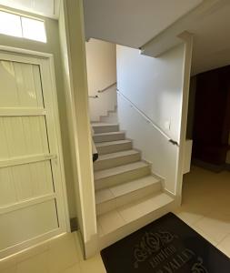 uma escada com uma porta e um tapete de escadas em Apartamento 2 quartos c/ garagem em Ponta Grossa