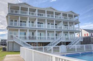 a large white building with a pool in front of it at TSC203 Fisher Oceanfront Elevator in Kill Devil Hills