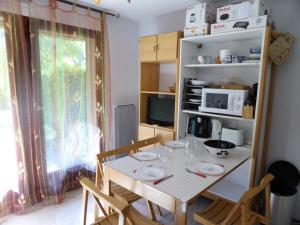 a kitchen with a table with chairs and a microwave at Résidence Borgia - Studio pour 4 Personnes 67 in Les Contamines-Montjoie