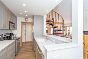 テルライドにあるAmazing View 2 Bed-2 Bath plus Loft Condo at Lulu Cityの白いカウンターとらせん階段付きのキッチン