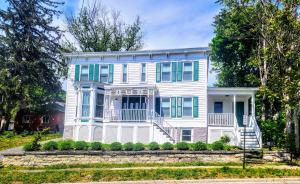 een wit huis met blauwe luiken op een straat bij Private Village Home in Catskill Splendor in Catskill