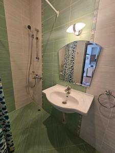 a bathroom with a sink and a shower with a mirror at Europroperties Yalta Apartments in Golden Sands