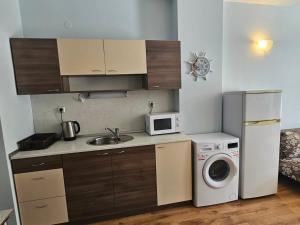 a kitchen with a washing machine and a microwave at Europroperties Yalta Apartments in Golden Sands