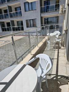 a balcony with chairs and tables and a building at Europroperties Yalta Apartments in Golden Sands