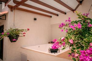 baño con flores rosas y bañera en Casa de descanso cerca al cañon del Güejar, en Granada