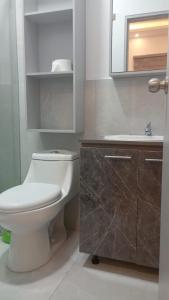 uma casa de banho com um WC branco e um lavatório. em HOSTAL SALINAS HOUSE em Salinas
