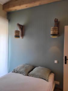 a bedroom with a bed with two pillows on it at Bel des Prés - Mantéros in Carquefou