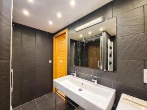 een badkamer met een wastafel en een spiegel bij Résidence Hameau - Chalets pour 8 Personnes 53 in Flaine