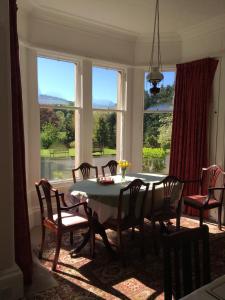 a dining room with a table and chairs and windows at Whitchester Christian Centre in Hawick