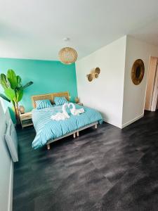 a bedroom with a bed and a blue wall at Chez romain in Massiac