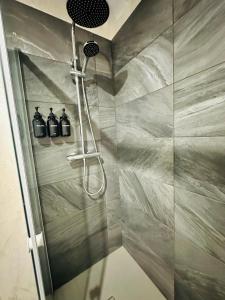 a shower with three bottles on the wall in a bathroom at Chez romain in Massiac