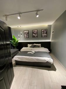 San Vito Luxury apartment في السويمة: غرفة نوم بسرير كبير وبعض الصور على الحائط