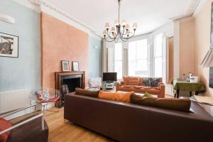 ein Wohnzimmer mit einem Sofa und einem Kronleuchter in der Unterkunft Inviting 1BD Hideaway Kensington Olympia! in London