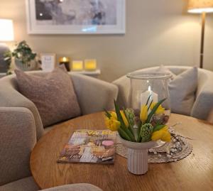 a table with a vase of flowers and a candle at Hotell Rådhuset in Lidköping