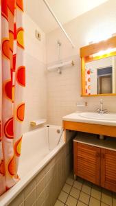 ein Badezimmer mit einer Badewanne, einem Waschbecken und einem Spiegel in der Unterkunft Chalet De L'arbaron - Studio pour 4 Personnes 92 in Flaine