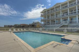 a swimming pool in front of a large building at TSC404 Seaclusion Oceanfront Elevator in Kill Devil Hills