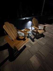 two chairs and a table on a patio at night at BlackMintHouse in Rakovac