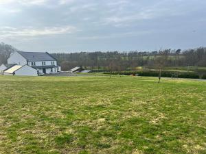 a large field of grass with a house in the background at Coylebrae House in Ayr