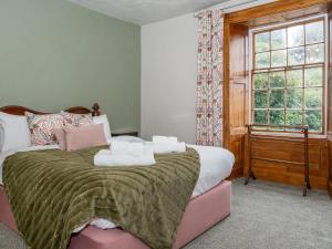 Un dormitorio con una cama con toallas. en Watermouth Castle, Rhododendron Apartment, en Ilfracombe