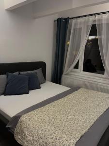 een slaapkamer met een bed en een raam met witte gordijnen bij The One in Sighişoara