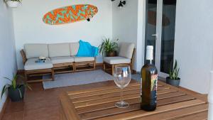 Una botella de vino sentada en una mesa con una copa de vino en Casa Mar Azul. en Tinajo