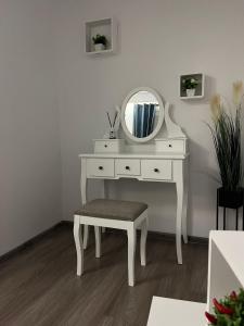 a white dressing table with a mirror and a stool at The One in Sighişoara