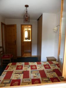 a bedroom with a bed with a quilt on it at Ancolie Chalets De La Vallee D'or - 3 Pièces pour 6 Personnes 84 in Valloire