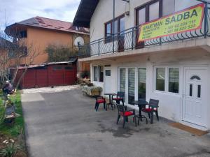a patio with tables and chairs in front of a building at Apartman Sadba in Goražde