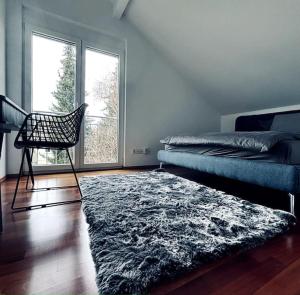 a bedroom with a bed and a chair and a rug at Lakefront View Entire Apartment with 2 bedrooms, 2 full bathrooms & Balcony Waterview in Reichenau