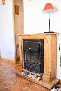 a wooden fireplace in a living room with a lamp at Résidence La Demeurance - 3 Pièces pour 6 Personnes 34 in Valloire