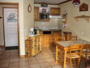 a kitchen with wooden cabinets and a table and chairs at Résidence Myosotis Hameau De La Vallee D'or - 2 Pièces pour 4 Personnes 64 in Valloire