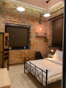 a bedroom with a bed and a brick wall at Apartament w sercu miasta in Wrocław