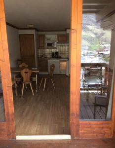 een keuken en eetkamer met een tafel en stoelen bij Résidence Gentiane Hameau De La Vallee D'or - 2 Pièces pour 4 Personnes 74 in Valloire