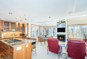 a kitchen and living room with red chairs and a fireplace at Spacious 3 bedroom Condo Easy walk to Grocery Store and Chairlift 7 in Telluride