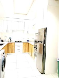 a kitchen with white cabinets and a stainless steel refrigerator at Luxurious 3Bedroom Apartment with Personal Chef in Maroko