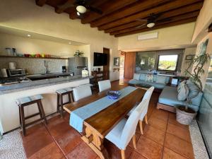 a living room with a table and a kitchen at Residences at Las Palmas in Zihuatanejo