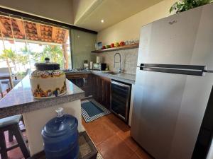 a kitchen with a refrigerator and a table with a cake at Residences at Las Palmas in Zihuatanejo