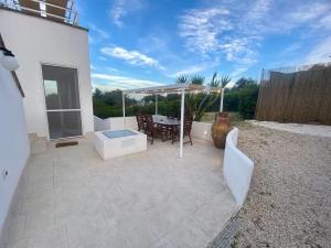 un patio con una mesa y una sombrilla en CASALE VISTA ADUA, en Ostuni