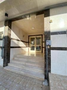 a lobby of a building with stairs and a door at المدينه المنوره in Sīdī Ḩamzah